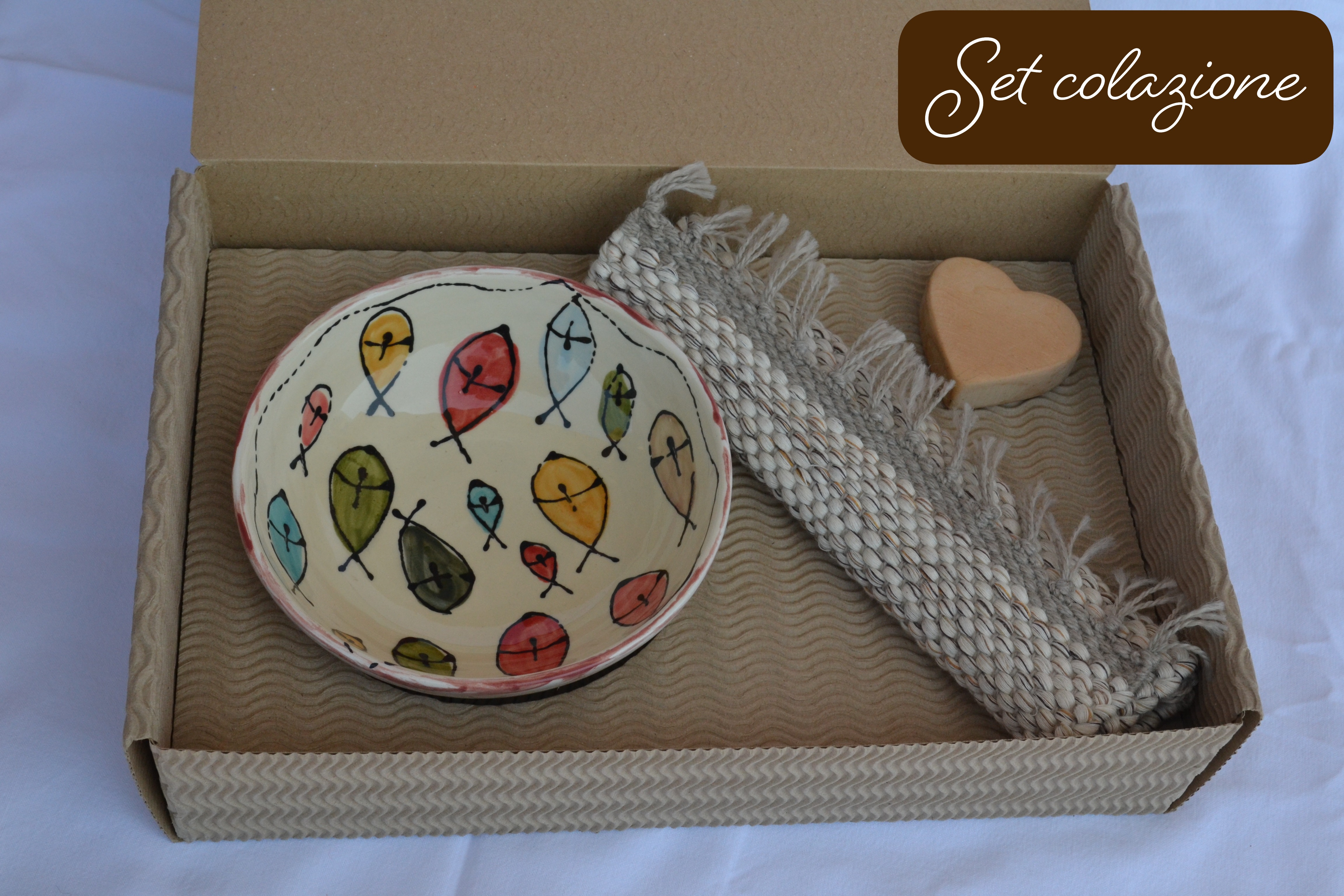 Set da colazione fatto a mano con una ciotola in ceramica decorata con pesci, un tappeto in tessuto riciclato e una saponetta a forma di cuore, in una confezione regalo